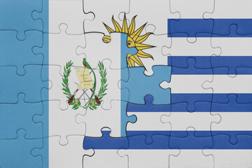 puzzle with the colourful national flag of uruguay and flag of guatemala .