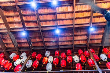 Old traditional vietnamese wooden ceiling with damaged wooden beams, rafters and terracotta tiles clay bricks in vietnam