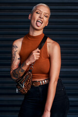 Young woman, funky and fashion with bag or tongue out for style on an outdoor dark background....