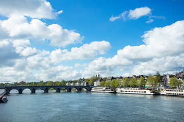 Obraz premium Picturesque Maastricht riverside skyline with boats and bridge