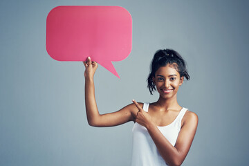 Girl, speech bubble and studio in portrait for social media, pointing and opinion on blue background. Text box, female person and review or vote on online post, networking and mockup on topic