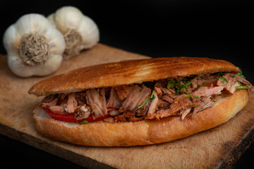 Shawarma and garlic on the wooden desk on black background