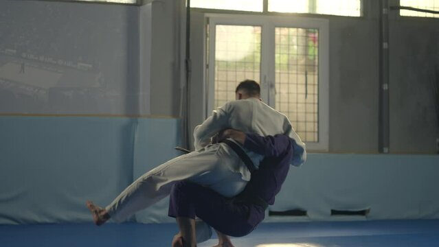 Jiu jitsu fighter in training sparing attacking from dominant position at the martial arts academy training class