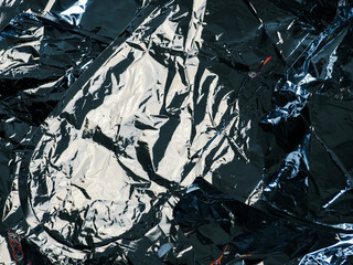 Silver crumpled foil texture for abstract background.    