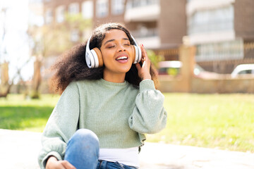 Young African American woman at outdoors listening music