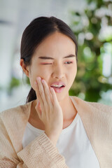 Young Asian woman suffering from toothache, tooth decay, tooth sensitivity, wisdom tooth pain, cavity, dental care concept