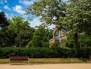 Obraz premium greenhouse facade and empty park bench at the Barcelona City park