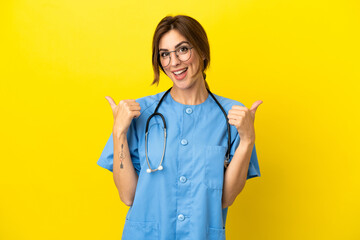 Surgeon doctor woman isolated on yellow background with thumbs up gesture and smiling