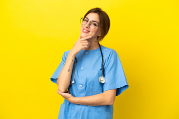 Surgeon doctor woman isolated on yellow background smiling