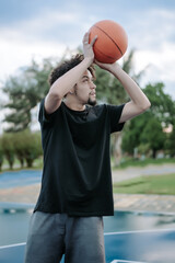 A single young man playing basketball