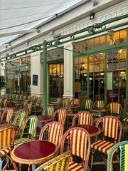 Multicolored chairs and tables adorn the terrace of a Parisian café in Paris, France.