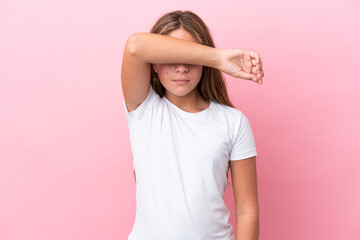 Little caucasian girl isolated on pink background covering eyes by hands