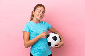 Little football player girl isolated on pink background giving a thumbs up gesture