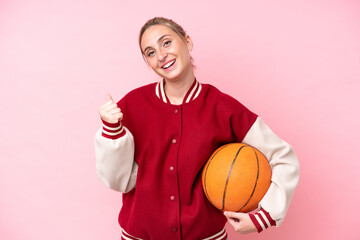 Young basketball caucasian player woman isolated on pink background celebrating a victory
