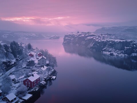 Aerial view of snowy Husoy village at winter in Senja, Norway with pink sunrise skies