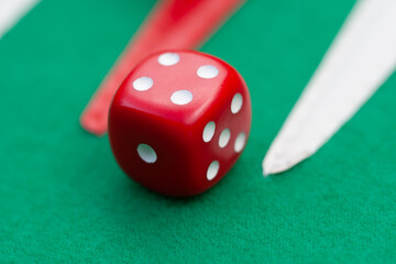 red dice rolling on green backgammon set, board games gambling close up