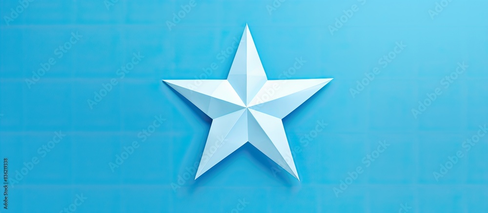 Wall mural origami star made of blue paper placed on a white background with copy space image.