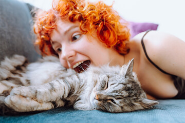 portrait red-haired teenage girl with gray fluffy cat