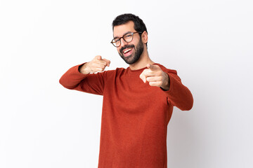 Caucasian handsome man with beard over isolated white background points finger at you while smiling