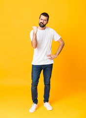 Full-length shot of man with beard over isolated yellow background with angry gesture