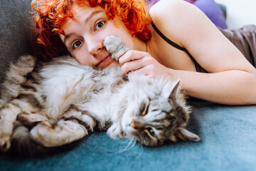 portrait red-haired teenage girl with gray fluffy cat