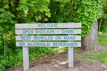 A close view of the green old wood park sign.