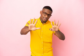 Young latin man isolated on pink background counting nine with fingers