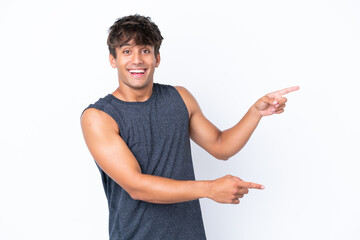 Young sport caucasian man isolated on white background surprised and pointing side