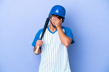 Baseball caucasian man player with helmet and bat isolated on blue background with tired and sick...