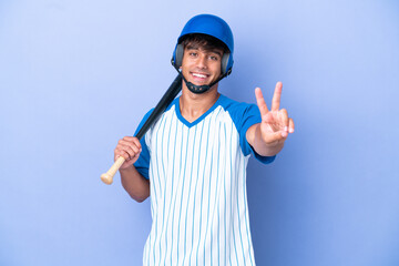 Baseball caucasian man player with helmet and bat isolated on blue background smiling and showing...