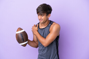 Young man playing rugby isolated on purple background suffering from pain in shoulder for having...