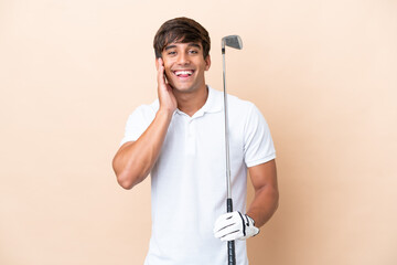Young golfer player man isolated on ocher background with surprise and shocked facial expression