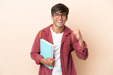 Young student caucasian man isolated on ocher background celebrating a victory in winner position