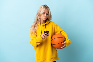 Young Russian woman playing basketball isolated on blue background thinking and sending a message