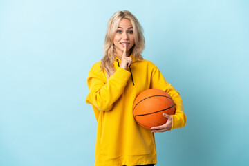 Young Russian woman playing basketball isolated on blue background showing a sign of silence...