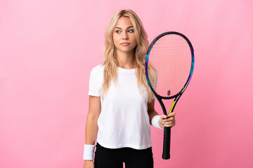 Young Russian woman playing tennis isolated on purple background having doubts while looking side