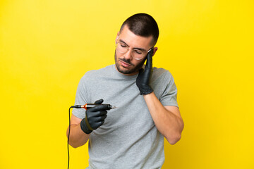 Tattoo artist caucasian man isolated on yellow background with headache