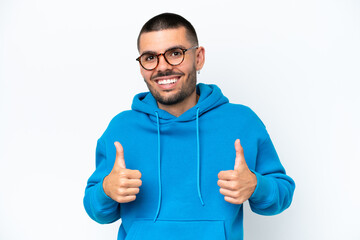 Young caucasian man isolated on white background With glasses and with thumb up