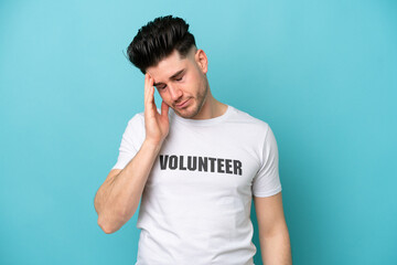 Fototapeta premium Young volunteer caucasian man isolated on blue background with headache