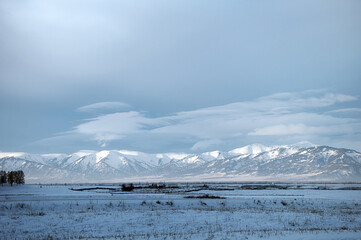 Cold snowy mountain landscape at sunset.
