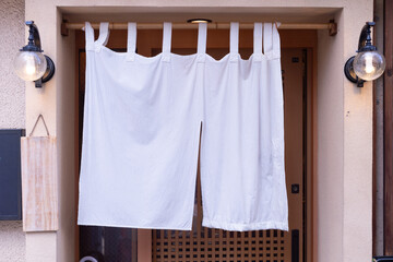 The curtain-like fabric that hangs in front of traditional Japanese restaurants and shops not only...