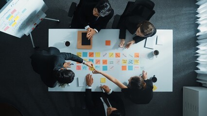 Top down aerial view of business group sharing and brainstorming idea by using sticky notes at...