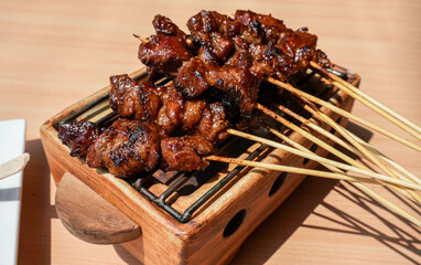 Homemade lamb or mutton satay marinated with spice and sweet soy sauce, coriander goat satay, served with chilli, soy sauce and tomato. Indonesian traditional satay