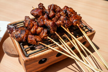 Homemade lamb or mutton satay marinated with spice and sweet soy sauce, coriander goat satay, served with chilli, soy sauce and tomato. Indonesian traditional satay