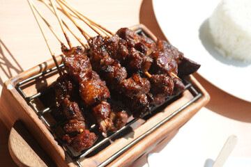 Homemade lamb or mutton satay marinated with spice and sweet soy sauce, coriander goat satay, served with chilli, soy sauce and tomato. Indonesian traditional satay