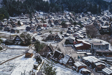 Shirakawa-go in winter, snow falling over the ground, house, historic village in valley, Japan.