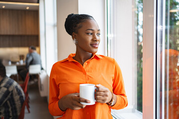 Woman in Orange Shirt Holding Coffee Cup