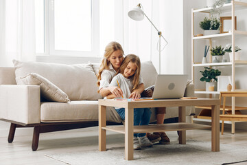 Mother and child bonding time on couch, engaged with laptop for learning and entertainment