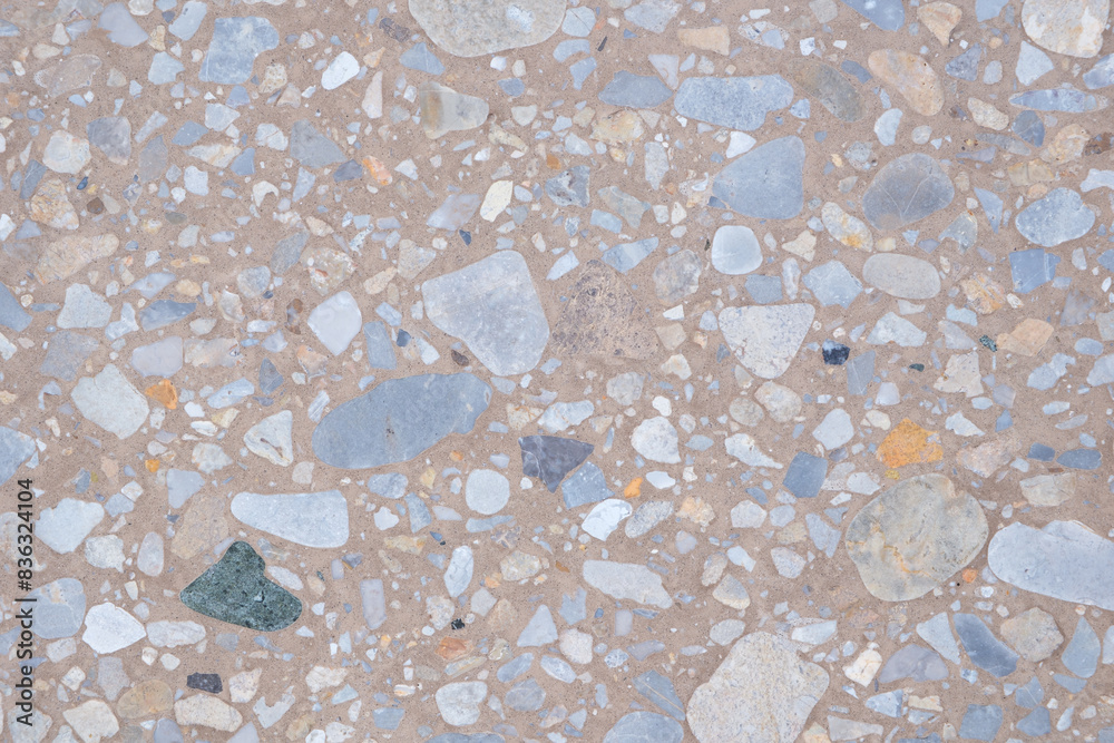 Poster A background with a lot of different colored rocks scattered all over it. The rocks are of various sizes and colors, creating a visually interesting and unique pattern