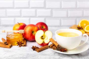 Fragrant hot tea with cinnamon stick and anise on a textured wooden background. A cup of hot tea...